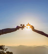 © AungMyo - Human hands holding jigsaw puzzle at sunset background.team work and success and strategy concept.