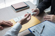 © Ngampol - Dishonest cheating in illegal money, Businessman giving bribe money the form of dollar bills to while give success the deal to contract agreement, Bribery and corruption concept