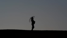 Silhouette Of A Pregnant Woman With An Umbrella