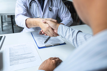 Wall Mural - Doctor having shaking hands to congrats with patient after recommend sickness treatment while discussing explaining his symptoms and counsel diagnosis health, healthcare and assistance concept