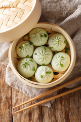 Wall Mural - Fresh baozi in bamboo steamer on Chinese Asian food closeup. Vertical top view