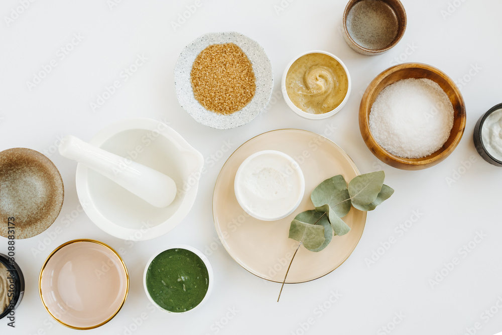 Beauty treatment ingredients for making homemade skin care cosmetic mask. Various bowl with clay, cream, essential oil and natural ingredients  on white table background. Organic spa cosmetic products - obrazy, fototapety, plakaty 