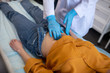 © zinkevych - Doctor in sterile gloves palping female patients stomach