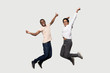 © fizkes - Energetic euphoric african american couple friends jumping with raised hands.