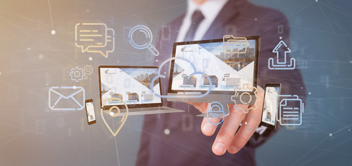 Poster - Businessman holding a Devices connected to a cloud multimedia network 3d rendering