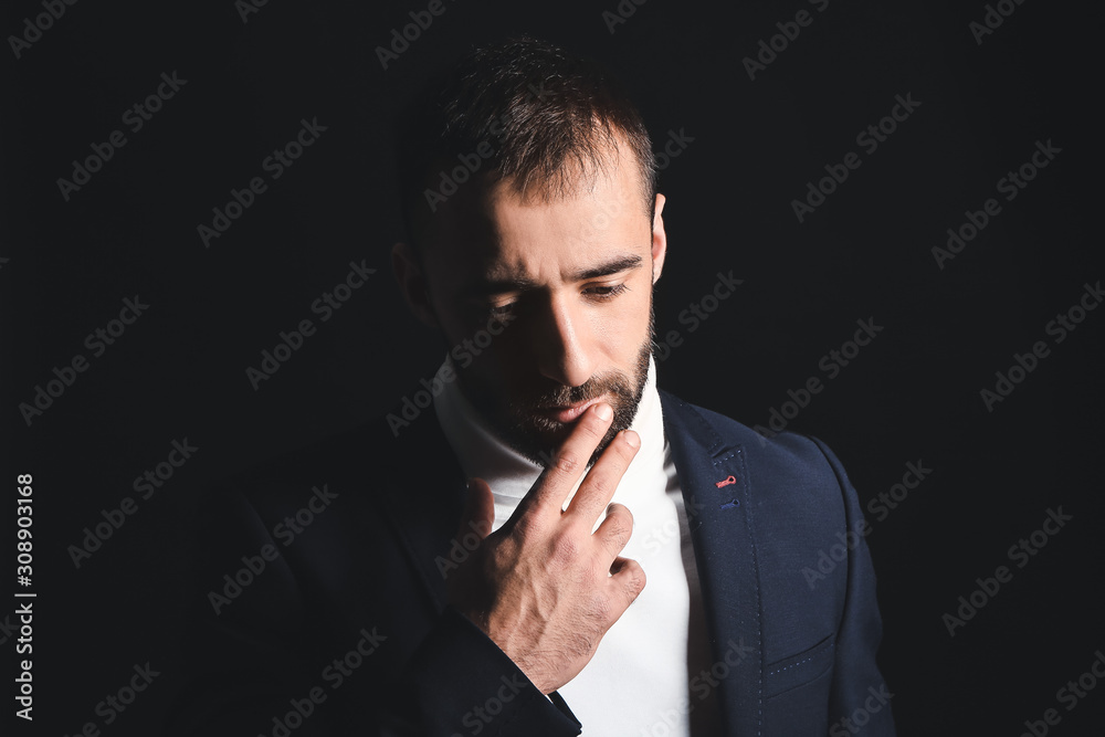 Portrait of sad young man on dark background