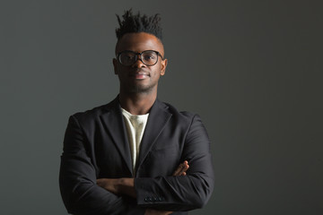 handsome african man in black suit on gray background