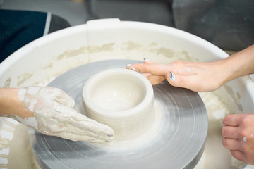 Women making ceramic pottery, concept for workshop and master class, four hands close-up, focus on potters, palms with pottery. Creative hobby concept. Earn extra money, side hustle