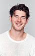 © Monkey Business - Studio Portrait Of Young Man Wearing White T Shirt Smiling At Camera