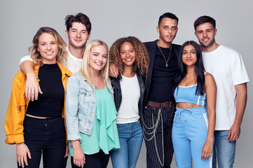 Group Studio Shot Of Young Multi-Cultural Friends Smiling And Laughing At Camera