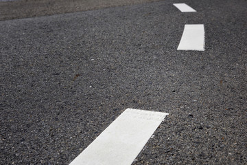 Closeup black asphalt road and white marking lines, copy space concept