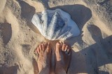 Fototapeta  - Stopy i wielka muszla na plaży