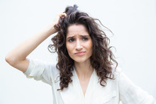 Worried Pensive Woman Scratching Head And Looking Away. Wavy Haired Young Woman In Casual Shirt Standing Isolated Over White Background. Hard Decision Making Concept