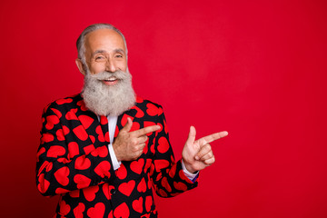 Close-up portrait of his he nice attractive cheerful cheery glad confident gray-haired man pointing two forefingers ad advert isolated on bright vivid shine vibrant red color background