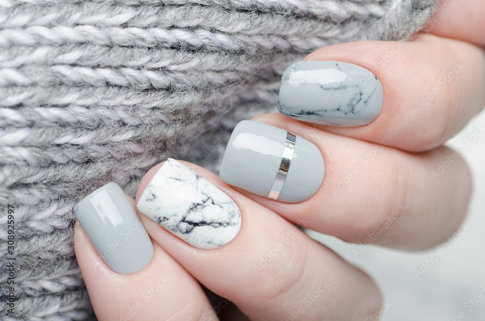 Fotografering white grey marble manicure with silver stripe on grey background