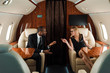 selective focus of happy african american businessman gesturing near businesswoman in private plane