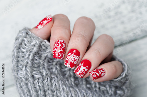 Fotografering red Christmas manicure with deer and snowflakes and Norwegian pattern