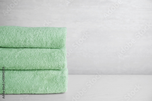 Fotomural Stack of clean bath towels on white wooden table. Space for text