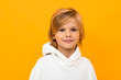 canvas print picture - portrait of blond boy grimacing on yellow studio background close-up