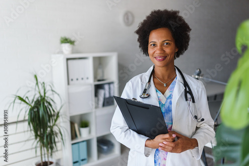 Cuadros en Lienzo Portrait of female African American doctor standing in her office at clinic