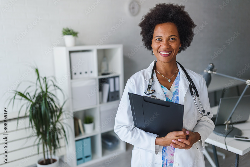 Portrait of female African American doctor standing in her office at ...