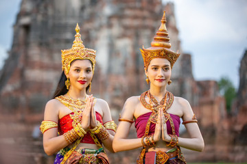 Portrait of woman with traditional costume in thai temple against statue of buddha in thailand