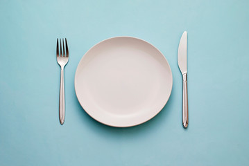 clean empty white plate with knife and fork