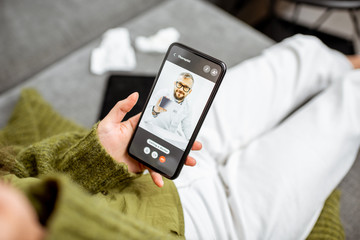 Woman talking with a doctor online using smartphone, feeling bad at home, close-up on phone screen. Concept of telemedicine and patient counseling online