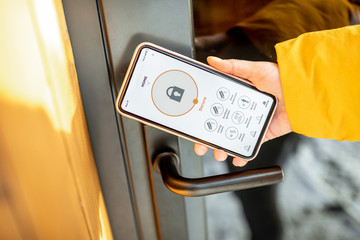 Locking smartlock on the entrance door using a smart phone remotely. Concept of using smart electronic locks with keyless access