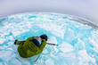 photographer takes pictures frozen clear ice in winter lake baikal, russia