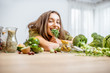 © rh2010 - Portrait of a young cheerful woman with pea seedlings and lots of healthy green food on the table. Concept of vegetarianism and well-being