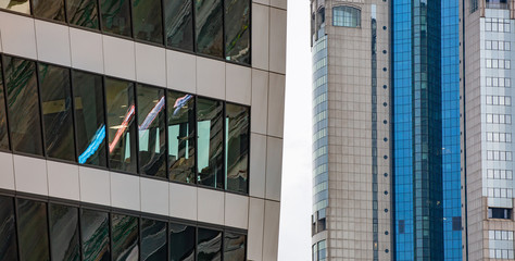 Fragments of two modern buildings close-up. A beautiful combination of various building structures and geometric details. Pattern of multi-colored lines and textures. Refractions and reflections.