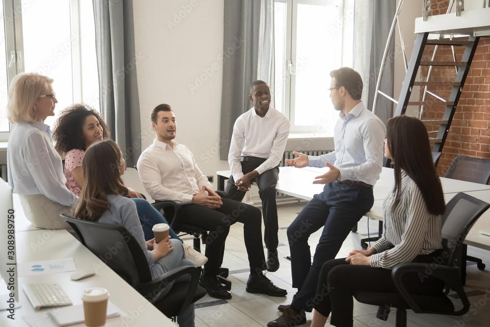 Multiethnic colleagues talk negotiating at informal office meeting - obrazy, fototapety, plakaty 