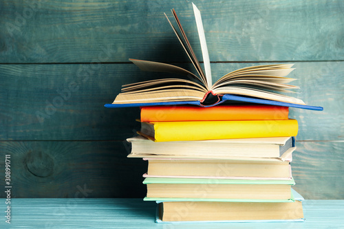 Fotografía Stack of colorful books on light blue wooden table