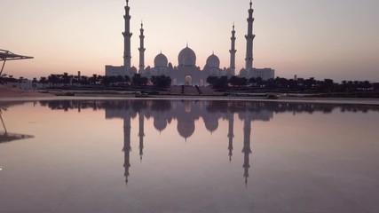 Wall Mural - Sheikh Zayed Grand Mosque reflected on the water in Abu Dhabi emirate of United Arab Emirates at sunset