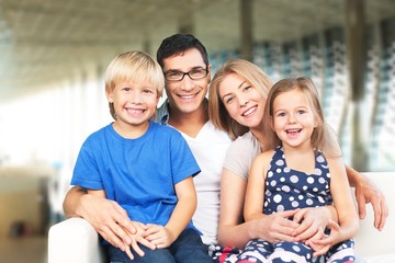 Wall Mural - Beautiful smiling happy family siting on sofa