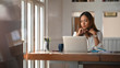 © Prathankarnpap - Asian woman working on home office table with thinking moment on laptop.