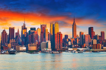 Fototapete - Manhattan skyline illuminated by sunset