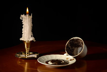Fortune Telling On Coffee Grounds. Mug, Saucer And A Burning Candle