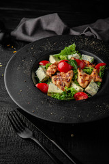 Wall Mural - Salad of iceberg lettuce, lettuce, cherry tomatoes, grilled chicken and dorblu cheese. Nutritious, dietary, fitness food. Black boards background
