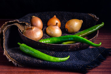 a vegetable plate of three green peppers with five golden onions