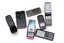 Lots Of Outdated Old Mobile Phones On White Background