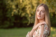 © ako-photography - Portrait of a young blonde woman against a defocused landscape. Autumn color shade.