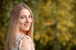 © ako-photography - Portrait of a young blonde woman against a defocused landscape. Autumn color shade.
