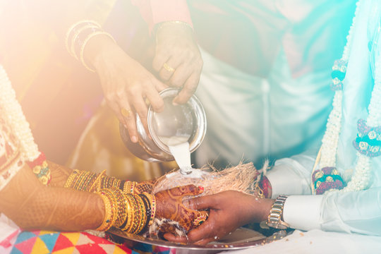 south indian bride and groom holding coconut. milk pouring ritual