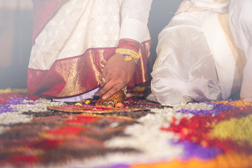 South Indian wedding ritual Saptapadi. Groom holding brides foot during marriage