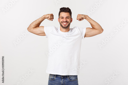 Cuadros en Lienzo Handsome fit young funny bearded man pointing to his bicep and smiling on white