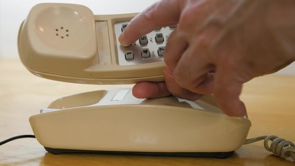 Wall Mural - Making telephone call on vintage landline phone. Man dialing retro push button rotary dial telephone. 