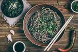 Fototapeta  - Still life with top view of traditional japanese soba noodles with nori (edible seaweed) and soy sauce, on a wooden surface closeup
