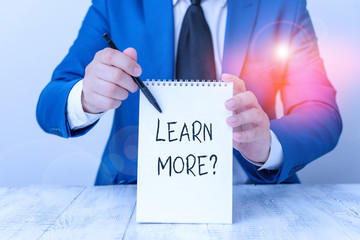 Poster - Handwriting text Learn More question. Conceptual photo gain knowledge or skill studying practicing Man holds empty paper with copy space in front of him Copy Space
